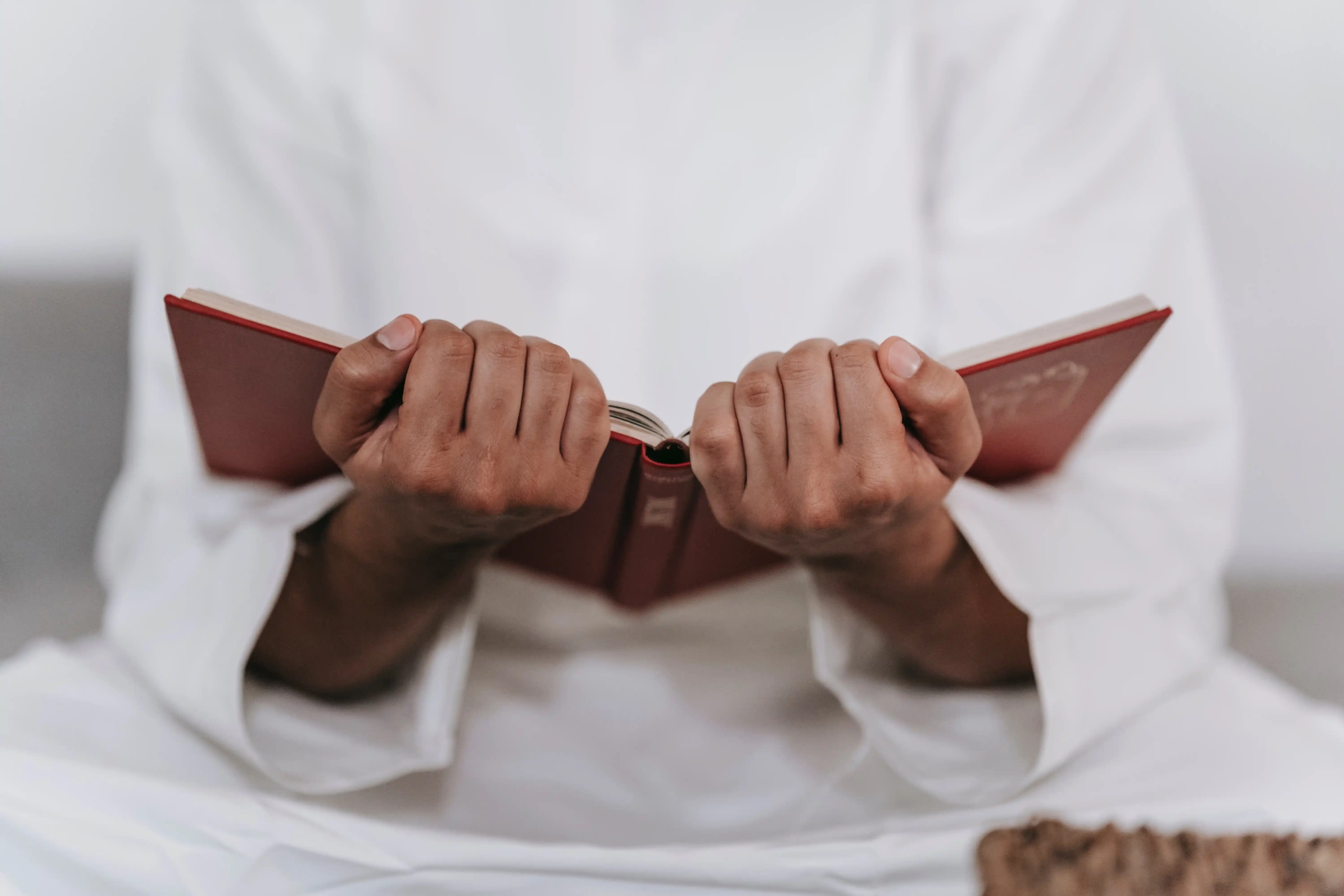 a man holding the Holy Quran in his hands.